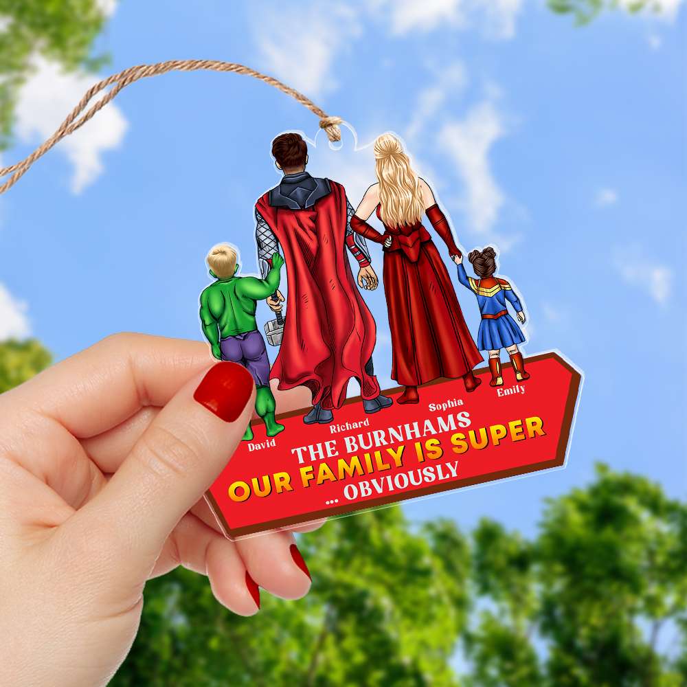 Our Family Is Super Obviously personalized acrylic ornament — held outdoors