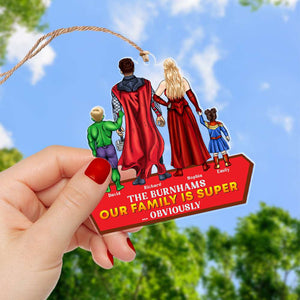 Our Family Is Super Obviously personalized acrylic ornament — held outdoors